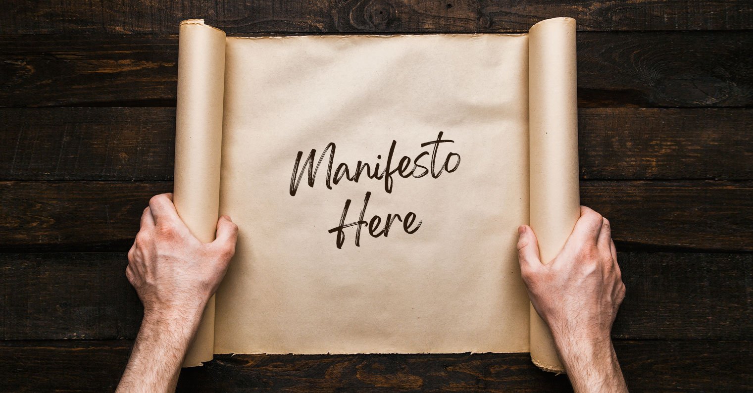 Two hands unroll butcher paper with "Manifesto Here" handwritten on it
