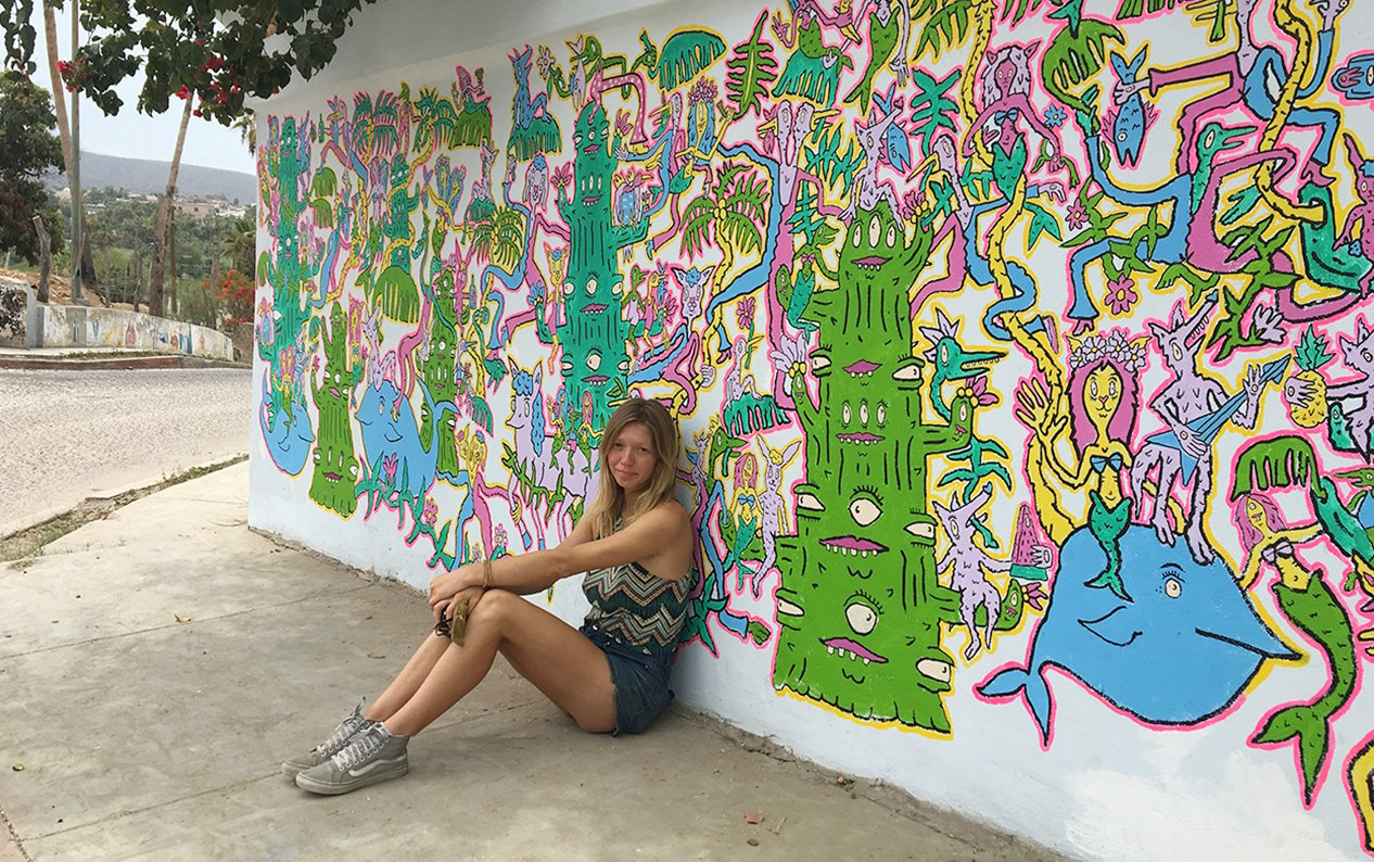 Bay area musician and artist Charlotte Hacker-Mullen in front of one of her many murals.